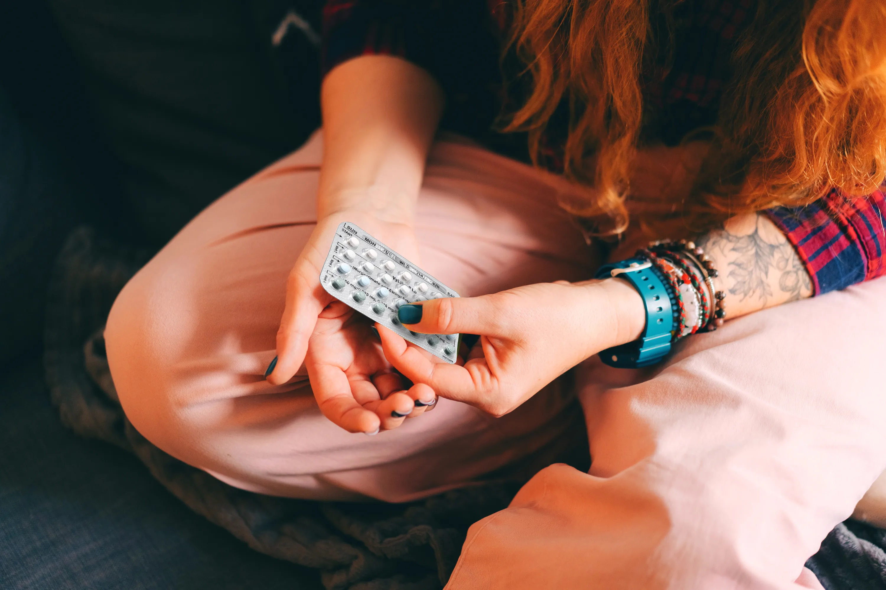 Young woman holding a pack of birth control pills